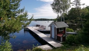 Stuga, strandtomt och egen brygga