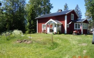 Liten röd stuga mellan två sjöar