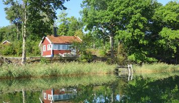 Stuga på strandtomt vid havsvik