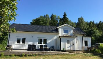 Stort hus med sjöutsikt och skogen inpå knuten ,