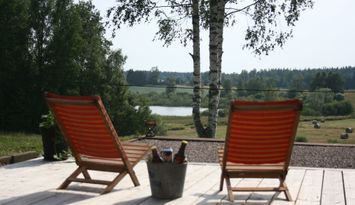 Hus i högt läge med sjöutsikt och skogen i ryggen