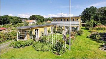 Havsnära äldre sommarhus med utsikt över en äng