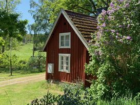 Torp på sjöställe med liten roddbåt