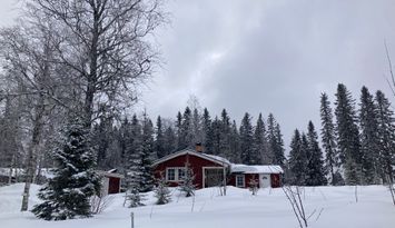 Ombonad stuga vid spår och sjö i Harsa
