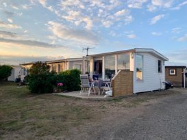 Nybyggd, mysig badstuga på Skrea strand
