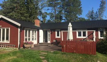 Modernt fritidshus nära hav och sandstrand.