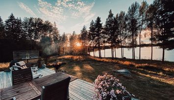 Idylliska stuga vid en sjö mitt i skogen