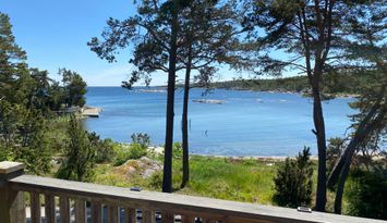 Röd liten stuga med drömläge precis vid stranden