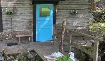 Mysig kvarnstuga intill sjö