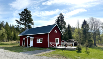 Mysig stuga i skogen på en gård