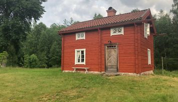 Mysig timmerstuga vid vattenspegel