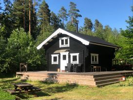 Sjönära stuga, med strand och båt