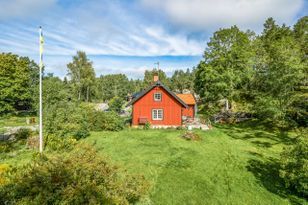 Stuga vid skog, ängar och sjö