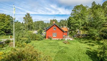 Stuga vid skog, ängar och sjö