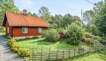 Stuga vid skog, ängar och sjö