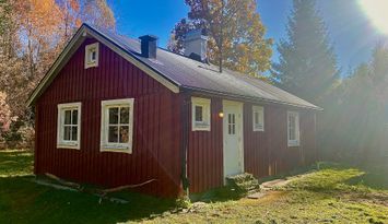En pärla mitt ute i skogen intill en sjö.