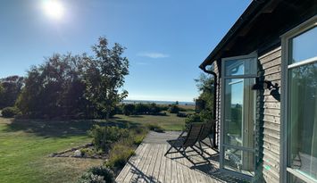 Vackert modernt trähus vid hav och strandängar