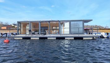 Schwimmendes Haus auf dem Wasser mit Boot in Blank