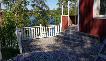 Liten stuga mellan sjö och skog