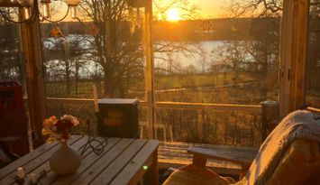 Stuga med sjöutsikt genom trädtopparna