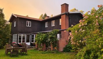 Stort lantligt hus vid skog, sjö och badstrand