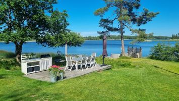 Stuga på sjötomt med 2 bryggor och båt