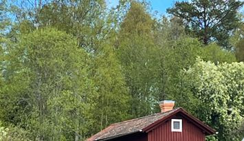 Röd liten stuga i Dalaidyll