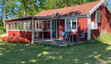 Röd liten stuga vid sjön