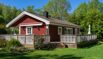 Sommarstuga med motorbåt vid sjön Åsnen