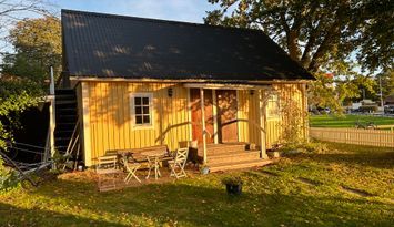 Charmig stuga på villatomt med havsutsikt