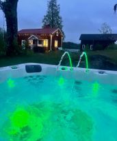 Stuga med sjötomt , ponnyer i hagen , jacuzzi .