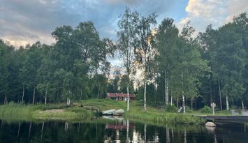 Sjötomt med brygga och båt