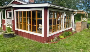 Stuga vid sjö och hav med båt