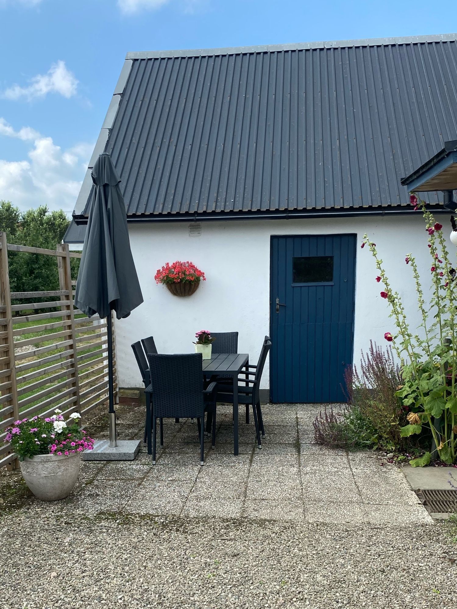 Litet hus vid fruktodling och hage.
