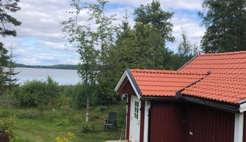 Liten stuga på standen av insjö