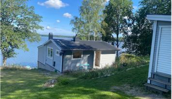 Mysig stuga vid en sjö med egen brygga